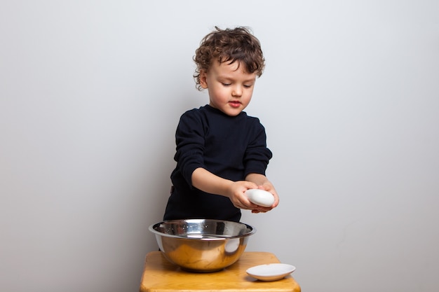 kid, boy learns to wash his hands with soap. hand disinfection.