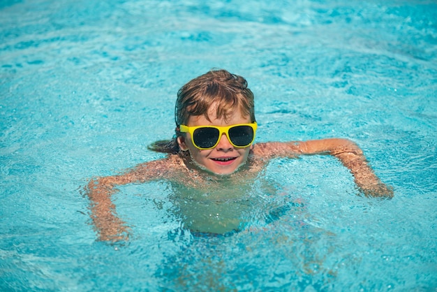 Kid boy playing and having fun on the beach on sea in summer. Blue ocean with wawes. Child boy swimming in sea.