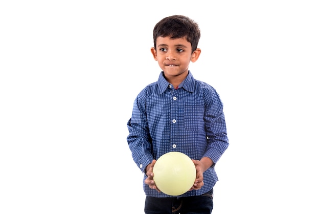 Kid boy playing with ball on white