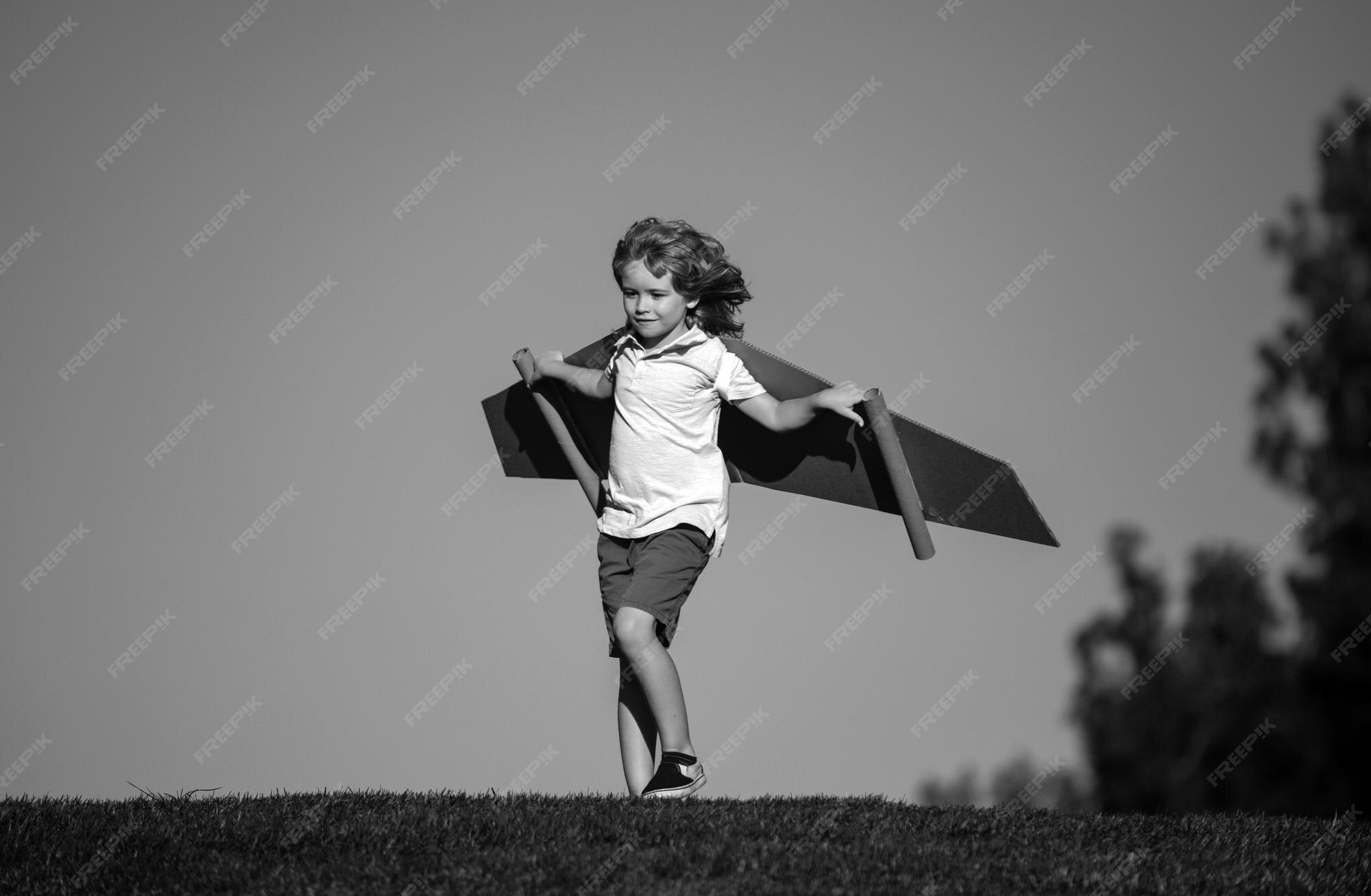 Premium Photo | Kid boy playing with cardboard wings child in summer ...