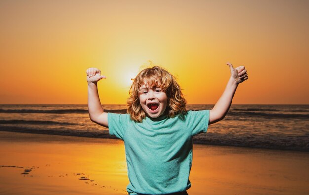 Kid boy on sunset beach raised hands amazed surprised kids emotions