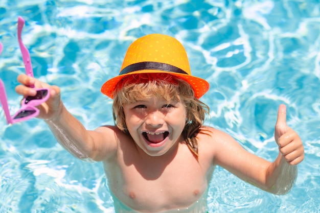 Kid boy swimming in pool play with floating ring smiling cute kid in sunglasses swim with inflatable