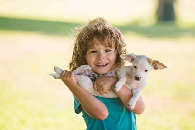 Kid boy with dog relaxing on nature lovely cute child embraces his pet doggy