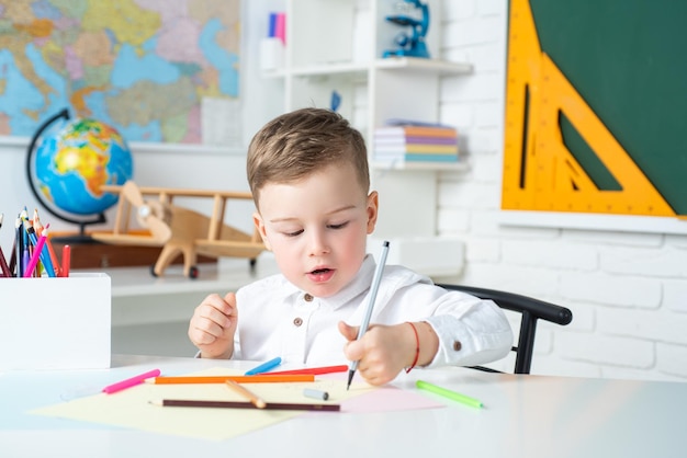 Kid boy writing in classroom Child of primary school