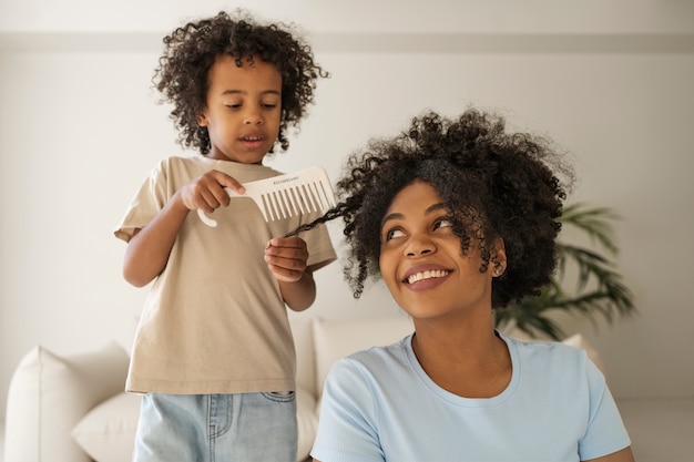 Kid brushing mother's hair front view