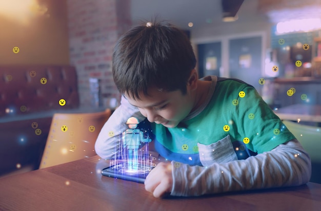 Kid building robot game on mobile phone with notification face icon pop upBoy programming Robot with double exposure of screen web surfingcyber diagram interfaceEducation technologyOnline learning