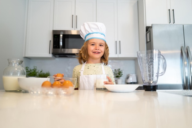 Kid chef cook in chef hat preparing food on kitchen Child making tasty delicious Cooking meal