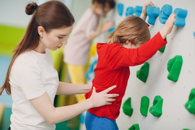 Kid child at climbing wall. Children sport, healthy lifestyle in kindergarten or sport center in school.