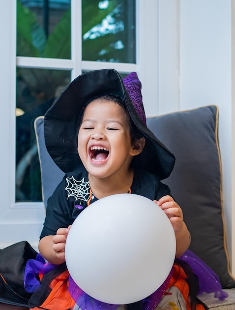 Kid costume for Halloween festival at home. Family celebration and decorated room in Autumn.