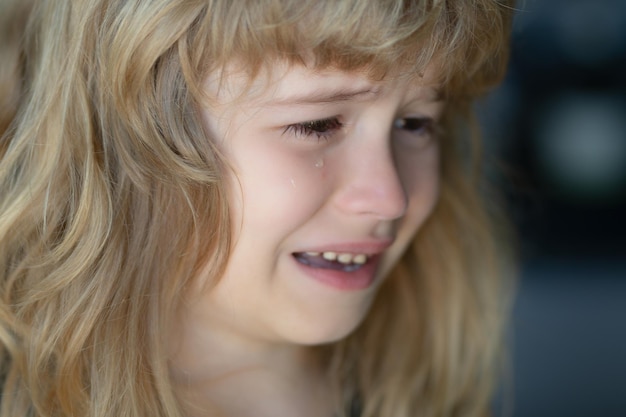 뺨에 눈물을 흘리며 우는 아이 슬픈 표정으로 우는 아이 우는 슬픈 아이