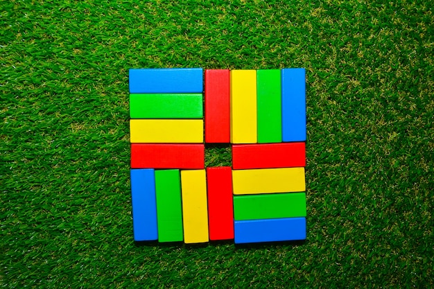 Foto blocchetto di legno variopinto di progettazione del bambino su erba verde