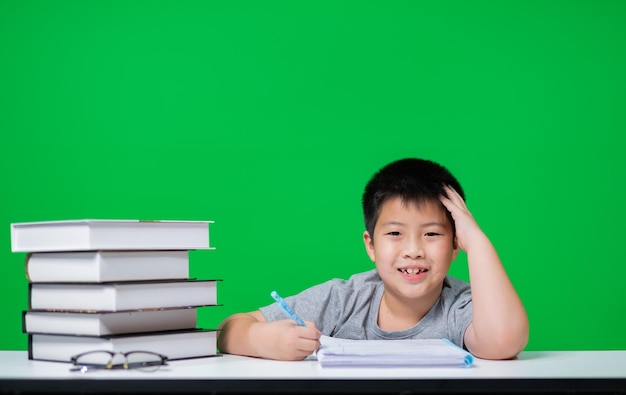 kid doing homework on green screen child writing paper education concept