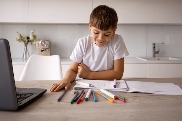 Foto bambino che disegna a casa vista frontale