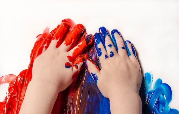 Il bambino disegna con le mani il primo disegno con le vernici concetto di arte e educazione creativa