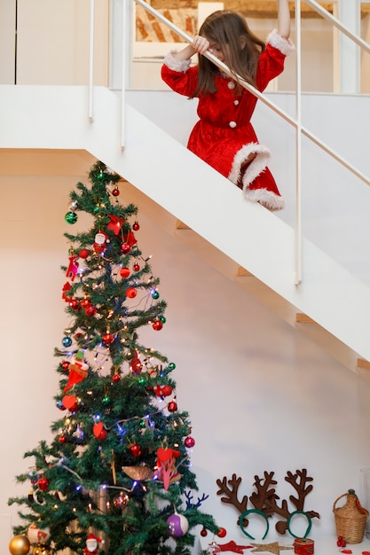 Photo kid dressed like santa going downstairs for christmas gifts