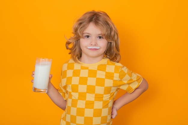 Kid drink fresh milk Cute kid drinking milk on yellow background