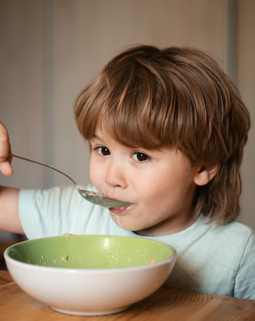 건강을 먹는 어린 소년을 위해 부엌 음식과 음료에서 아침 식사를하는 어린 소년을 먹는 아이
