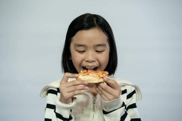 Ребенок ест пиццу на белом фоне