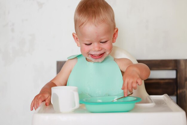 Il bambino mangia con un cucchiaio e impara da solo