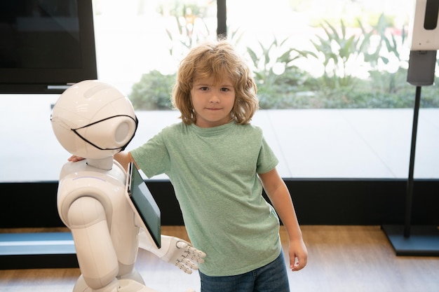 Kid en robotassistent met informatiescherm in beschermend masker. robot pandemie toekomst. robot hulp bieden aan kind. humanoïde technologie. kunstmatige intelligentie interactie met jongen.