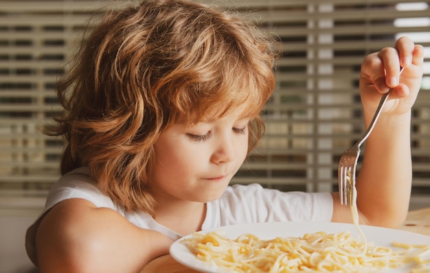 Kid eten pasta spaghetti portret close-up hoofd van schattig kind