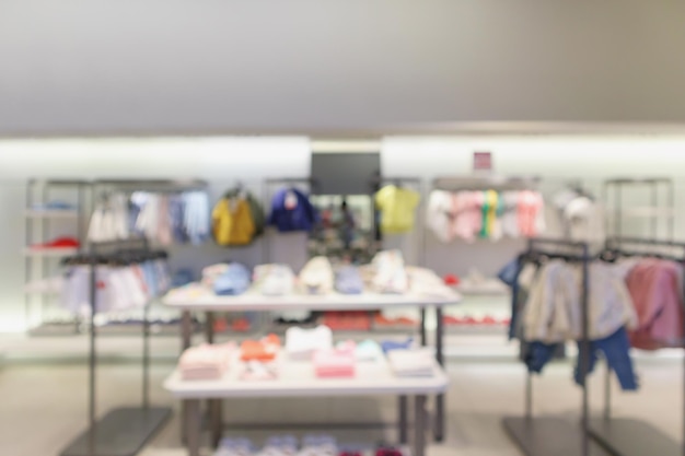 Kid fashionable boutique clothing store window display in shopping mall defocused blur background