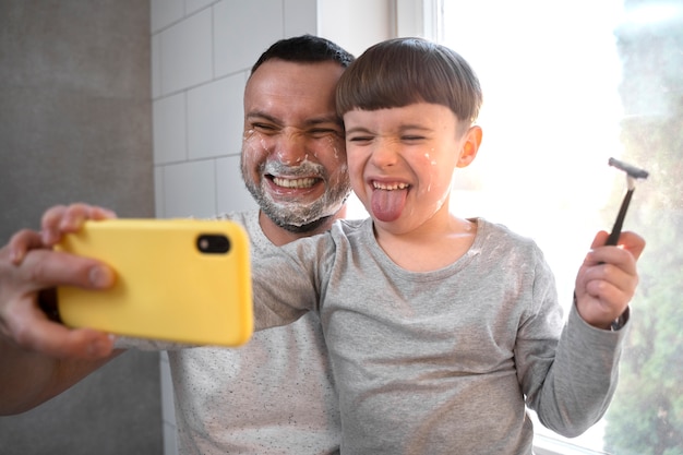 Photo kid and father taking selfie medium shot