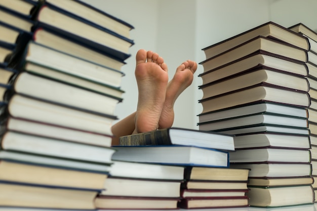 Piedi del bambino con un sacco di libri