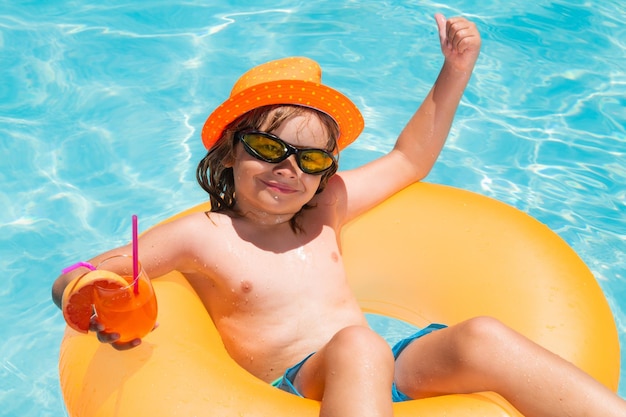 Kid floating in pool child relaxing in pool drink summer cocktail summer holidays and vacation with