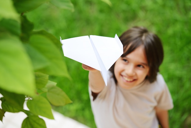 Foto kid volare un aeroplano di carta