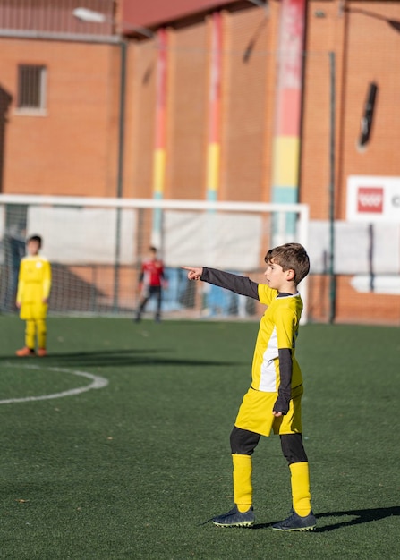 축구 경기에서 자신의 팀에게 방향을 제시하는 어린이 축구 선수