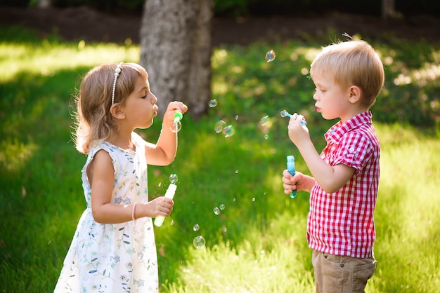 Bambino e amici giocano una bolla nel parco giochi con il tramonto