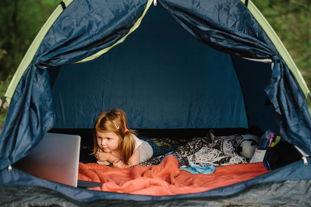 Kid girl in a campaign in a tent