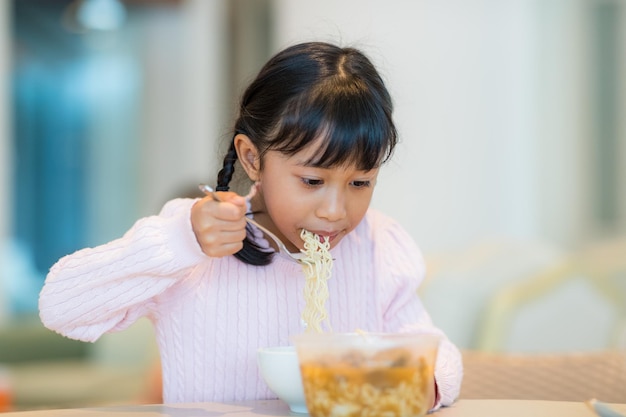 Photo kid girl eat instant noodles