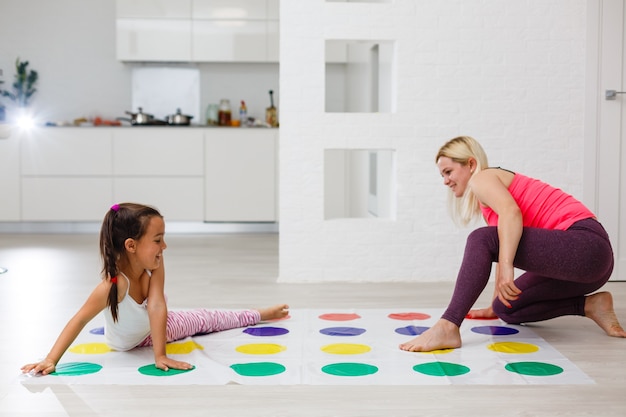 kid girl and mother playing together at home