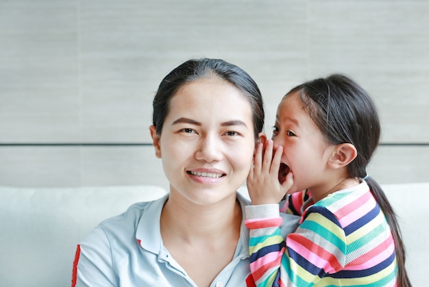 사진 어머니의 귀에 험담을 속삭이는 아이 소녀.