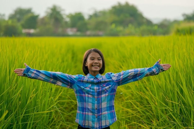 Kid glimlach en staat in biologisch rijstveld