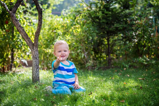 Kid on the grass under the tree