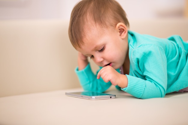 スマートフォンで遊んでいる子供と半月齢。