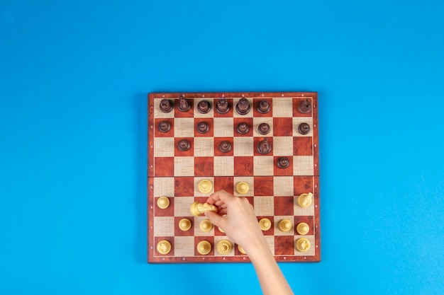 Kid hands over a chessboard playing chess game