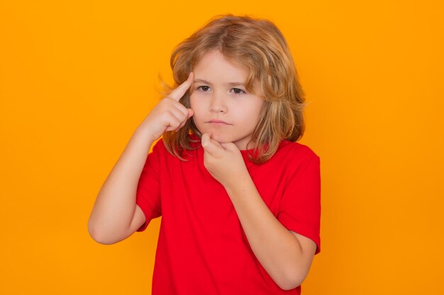 Kid have idea on yellow isolated background child pointing up fingerand thinking on yellow