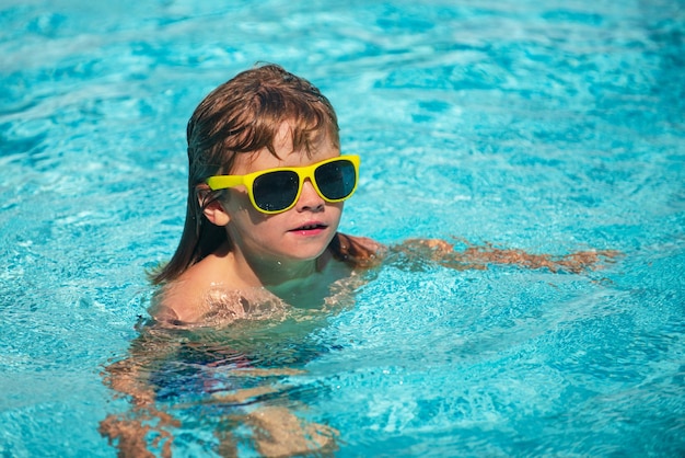 Kid having fun in swimming pool kid in sunglasses relax on beach