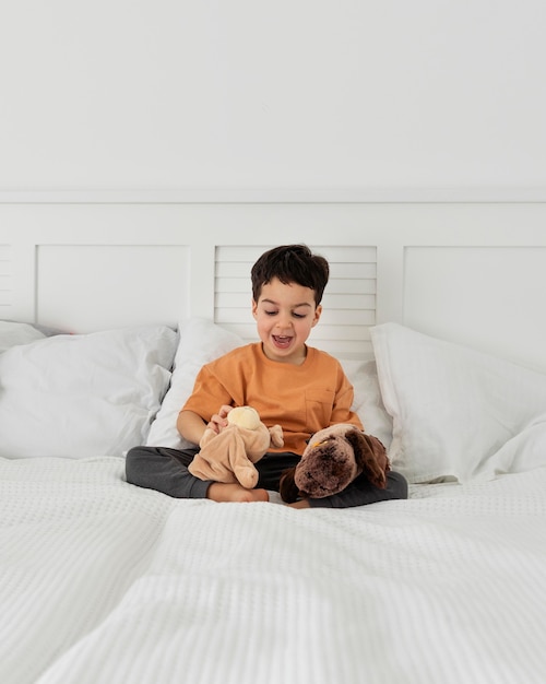 Kid having fun with his toys in bed