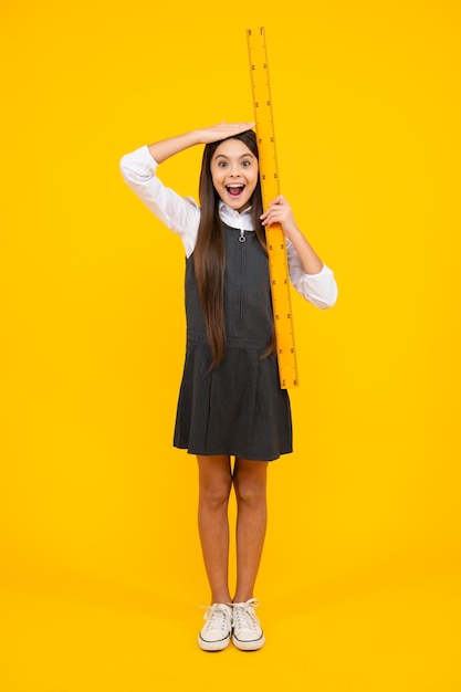 Kid height measure growth measurement Schoolgirl holding measure for geometry lesson isolated