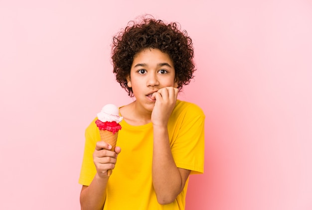 Kid holding an ice cream and biting fingernails