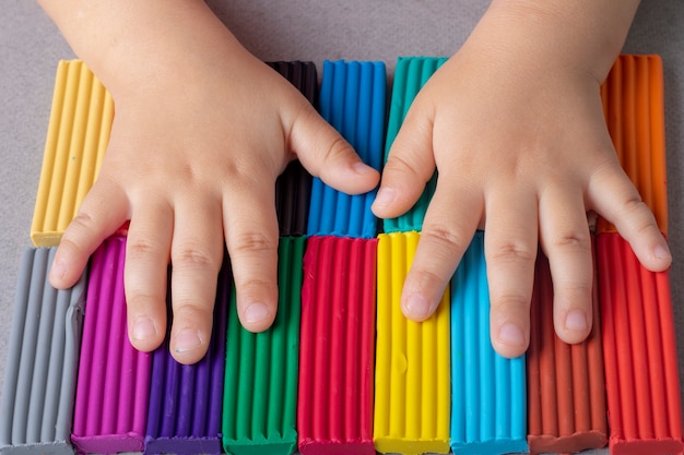 Kid holding new plasticine sticks.