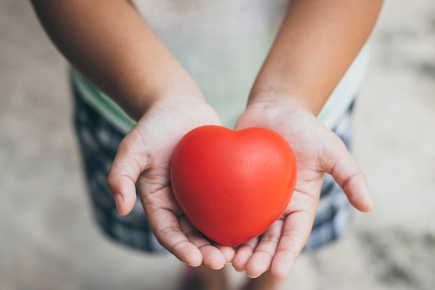 Photo kid holding red heart in hands