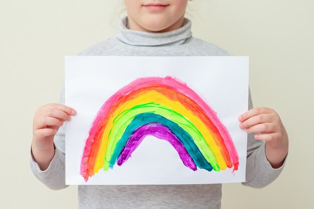 Kid houdt getekende regenboog