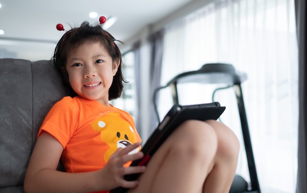 Kid is addicted to tablet, little girl playing smartphone, kid use telephone, watching cartoon