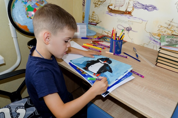 子供は家で絵を描いたり、書いたり、絵を描いたりしています。学校、リモート、オンライン教育。学校に戻る